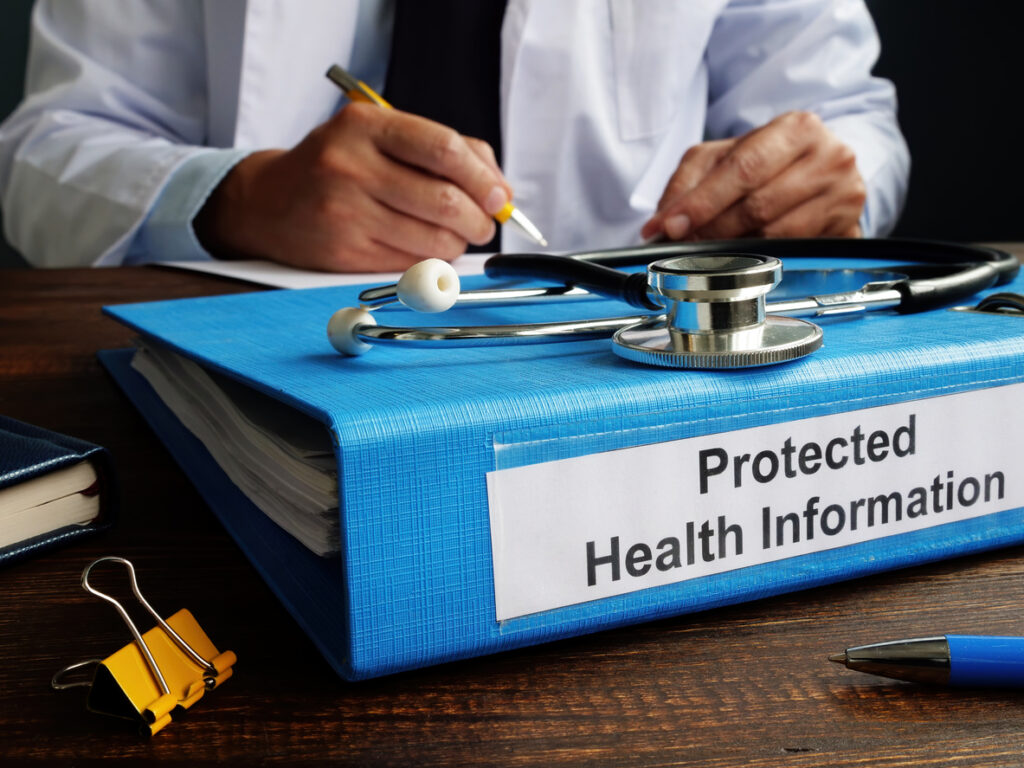 A doctor writing protected health information on a blue folder while ensuring HIPAA compliance in healthcare marketing.