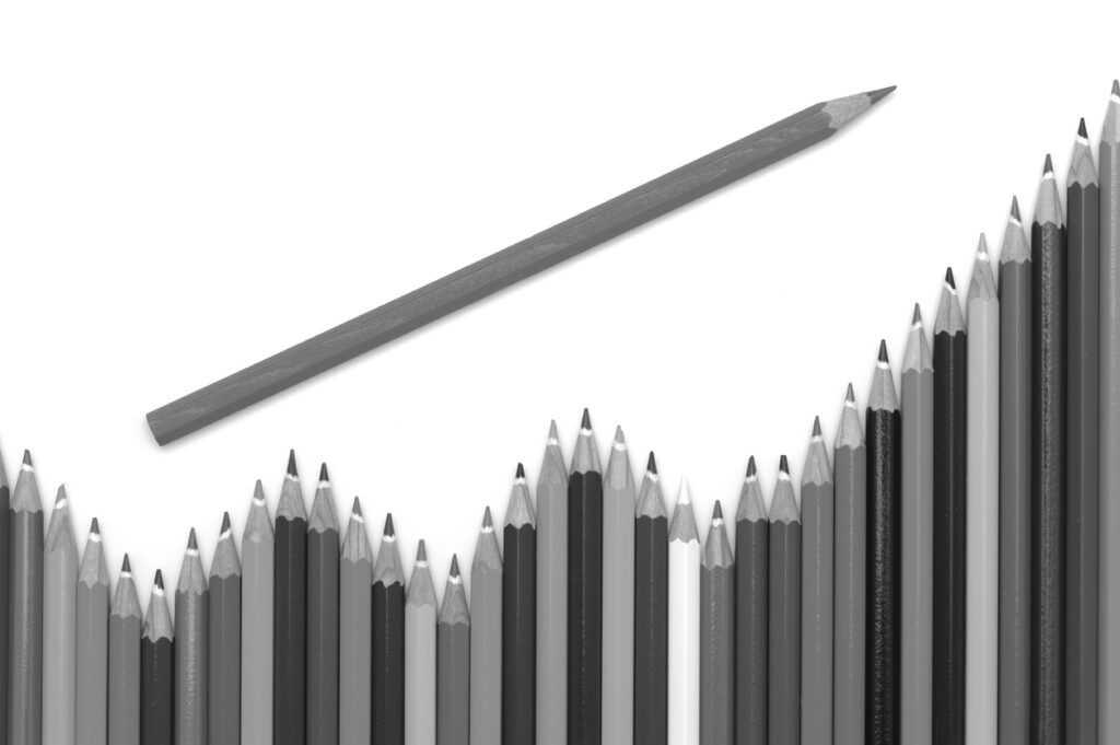 A pencil is going up a line of pencils on a white background.