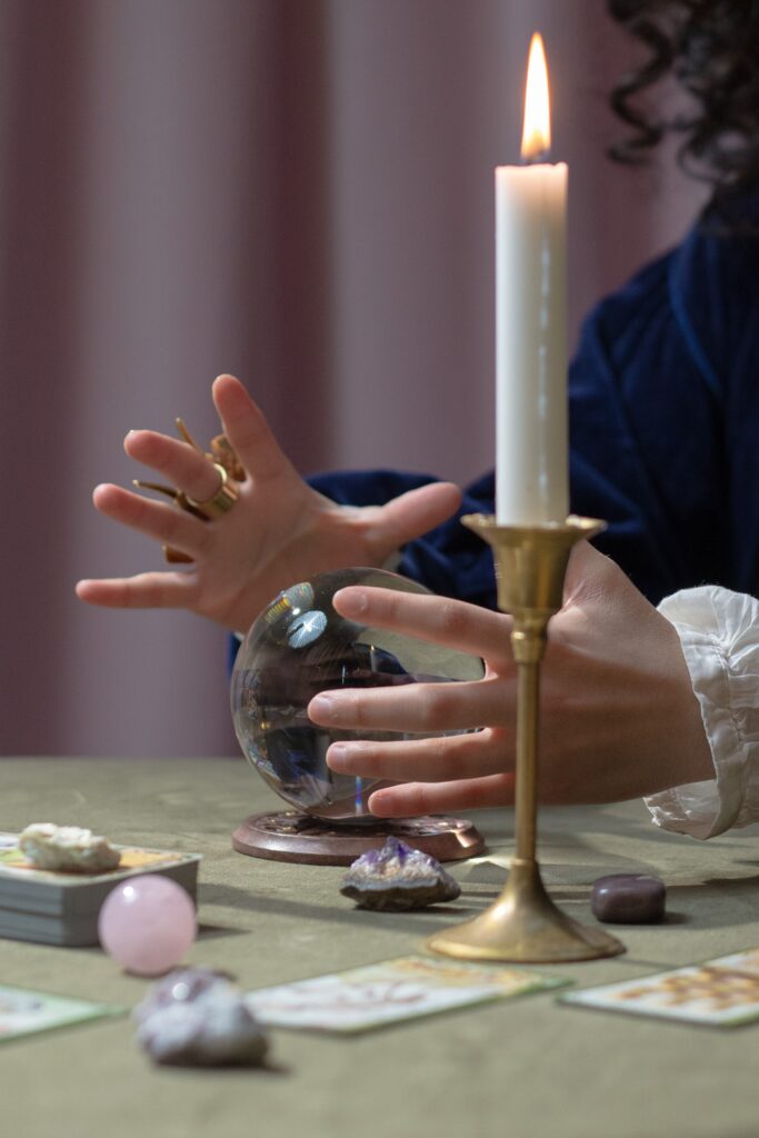 A woman is holding a candle and a crystal ball.