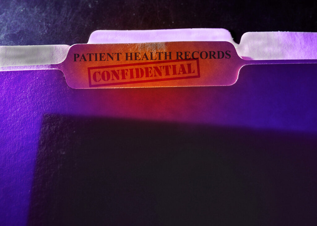 A file folder with the words patient health records confidential on it.