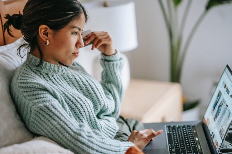 Woman, laptop, bed.